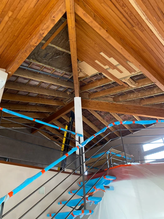 Chantier de rénovation dans combles avec ouvrier installant cloisons sèches