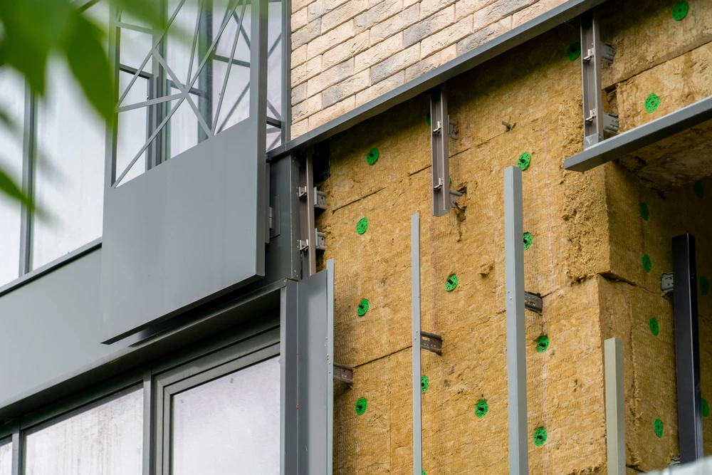 Chantier de construction extérieur avec pose d'isolation thermique par l'extérieur sur façade de maison individuelle