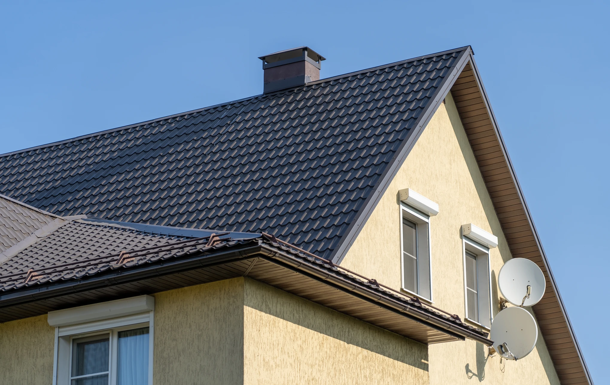 Chantier de couverture en extérieur avec ouvriers installant des tuiles sur toiture