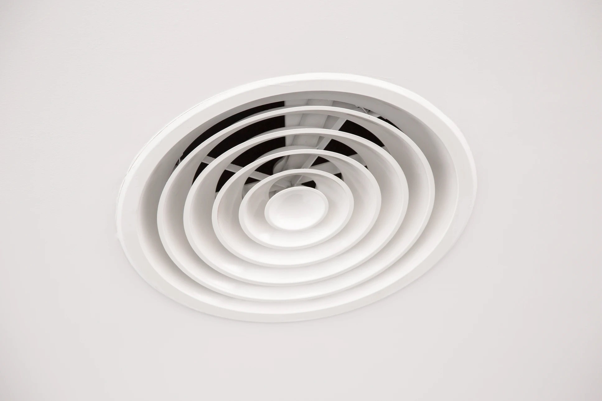 Ouvrier installant de l'isolation thermique entre les solives d'un plafond dans un grenier