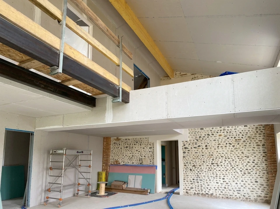 Ouvrier du bâtiment du toit installant du matériau d'isolation du toit sur une nouvelle maison en construction